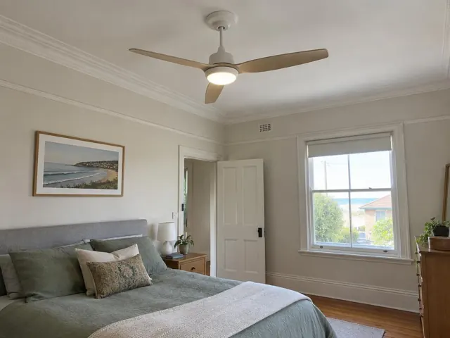 Ceiling fan on a bedroom ceiling with cornice, bed and window in Bar Beach